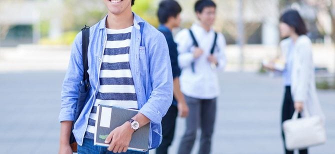 大学構内でほほ笑む男子学生