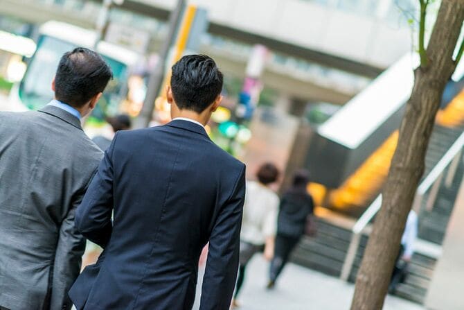 通りを歩く2人のアジア人ビジネスマン