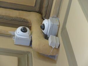 駅やバス停に取り付けられている小型の発信機（ビーコン）。CCTVカメラの下にある小さな箱から発信している