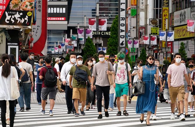 開催中の五輪の垂れ幕が掲げられた歌舞伎町を歩く人たち。東京都では7日、新たに4566人の新型コロナウイルス感染が確認され、4日連続で4000人を超えた