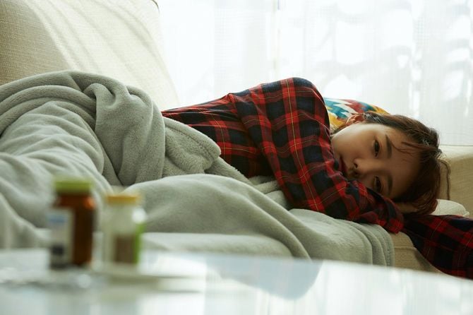 ソファで寝る病気の女性