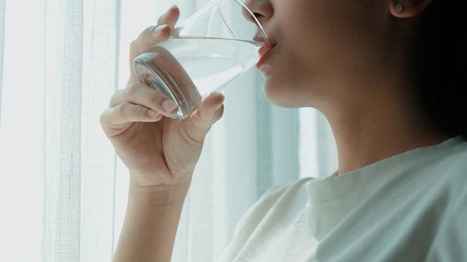 コップで水を飲む