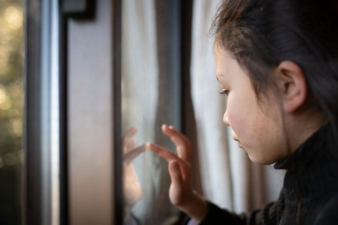 窓ガラスに触れる女の子