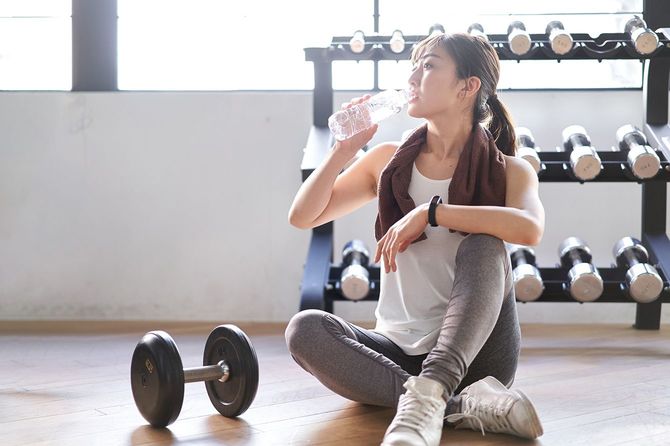 トレーニングジムで休憩を取る女性
