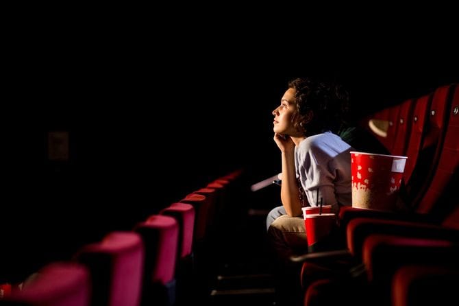 映画館で映画を見て楽しんでいる若い女性