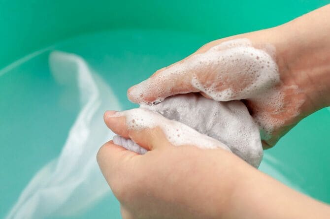 洗濯物を手で洗う子どもの手