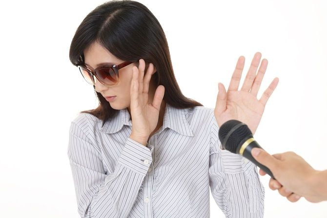 マイクを向けられて嫌がる女性