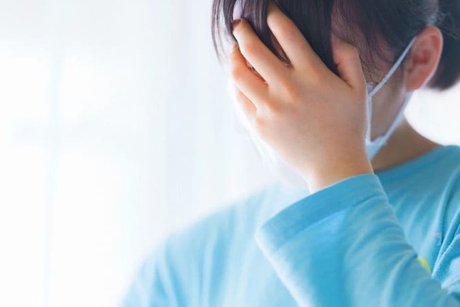 手で顔を覆う女性