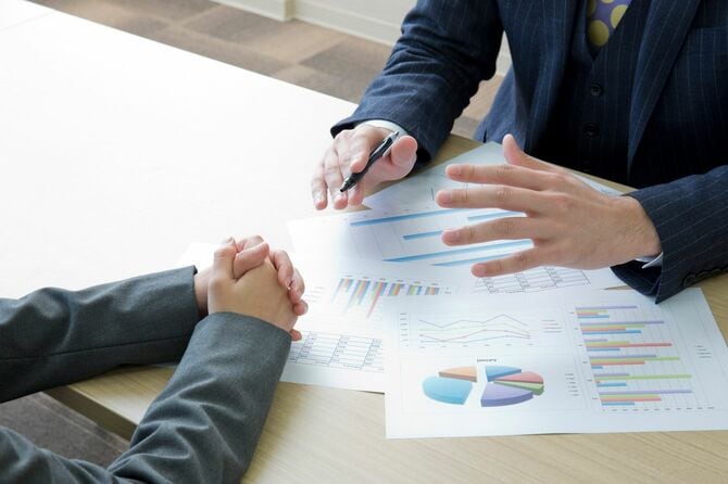 さまざまなデータをプリントした資料を交えて説明している