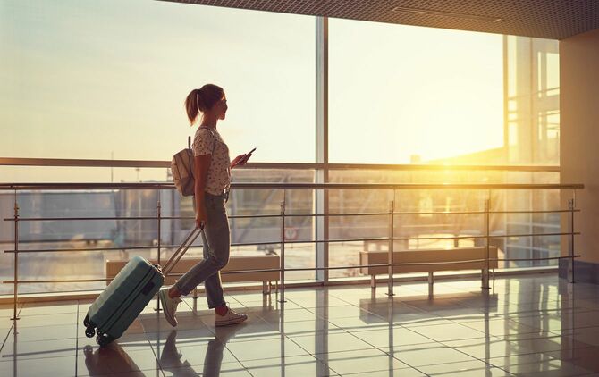 スーツケースを持って空港を歩く女性