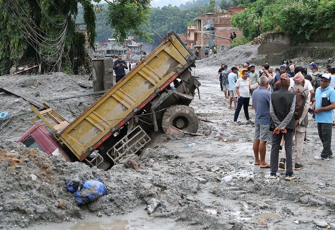 洪水により発生した大量の泥に埋もれ、道路脇で身動きが取れなくなったトラック=ネパール・ビドゥール、2026年8月29日
