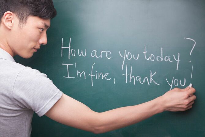 黒板に英語を書く若い男性