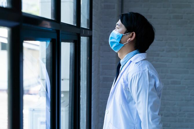 窓の外を眺める若い医師