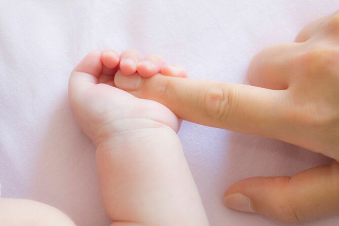 母親の指を握る赤ちゃんの手