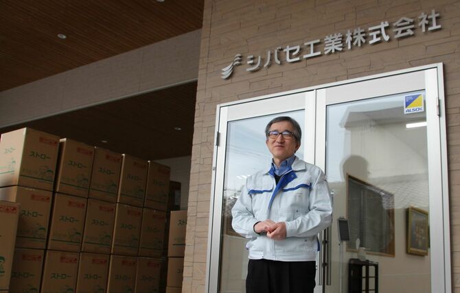 シバセ工業の磯田拓也社長。本社玄関横には大量の商品が積まれている