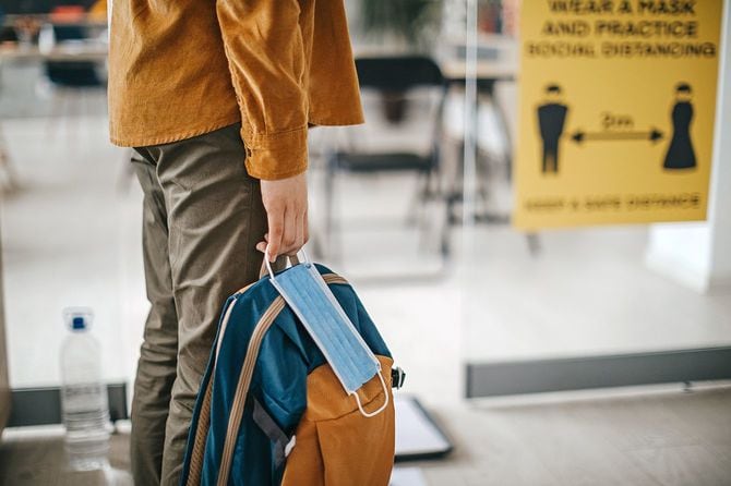 大学の入り口で立ち止まる学生