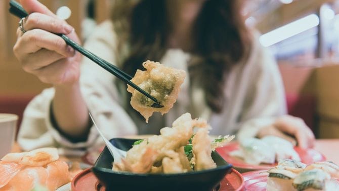 日本食レストランで食事をする女性
