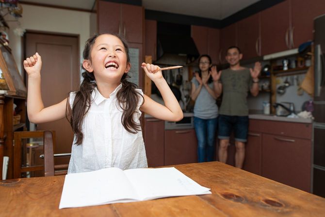 勉強で喜ぶ娘と一緒に喜ぶ両親