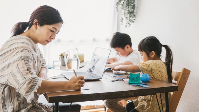 子供と一緒に家で働く母親