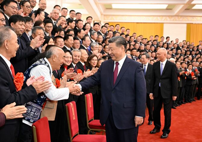 2024年12月31日、中国・北京の人民大会堂で、功労賞を受賞した退任幹部・団体の代表者と握手する習近平国家主席(中央)。