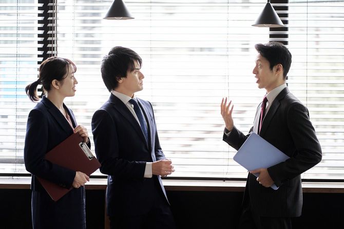 オフィスで議論するアジアのビジネスパーソン