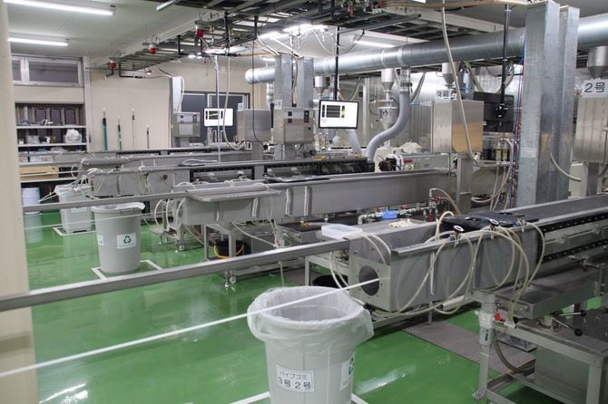 シバセ工業のストロー工場。カットされる前の白いストローが高速で押し出されていく