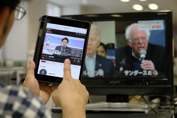 テレビ番組をインターネット配信するサービス「NHKプラス」の画面（左）＝2020年3月1日、東京都中央区