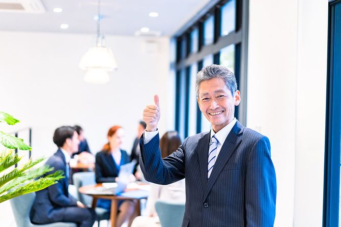 笑顔で仕事をする年配のビジネスパーソン