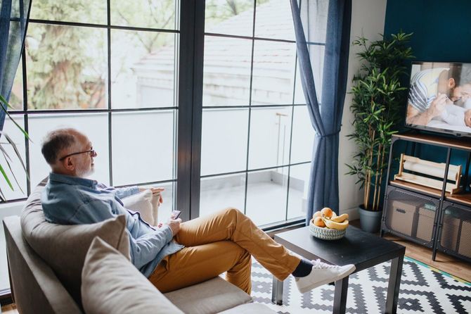 自宅でテレビを見ている男性