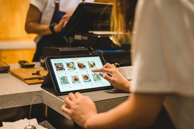 タブレットを使って料理の注文をする客