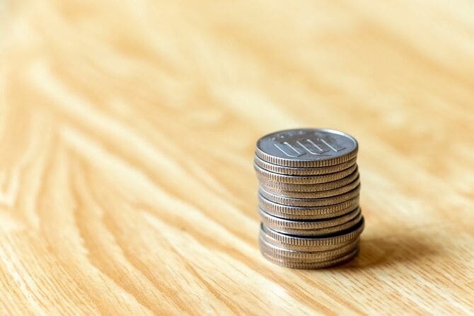 机の上に積み上げられた100円硬貨