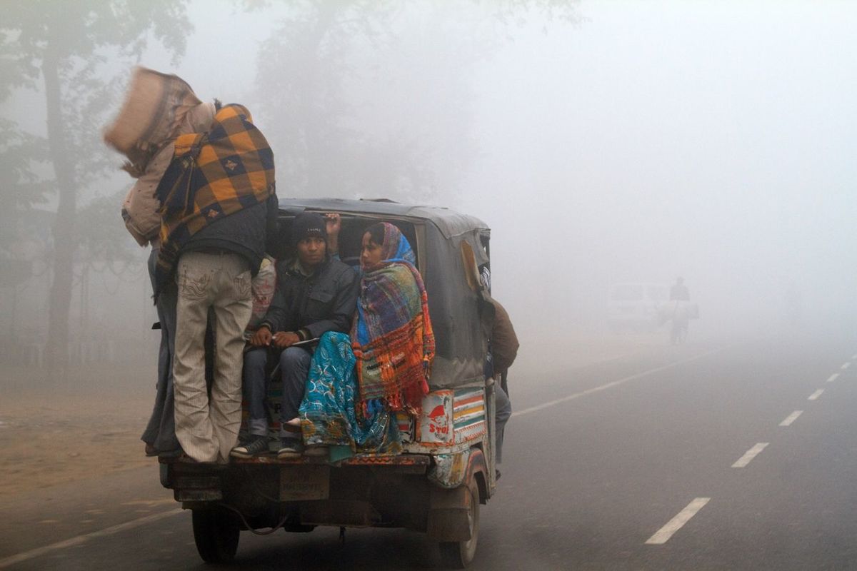 インド・ニューデリー インドの家族は、非常に厳しい気象条件のなか、リキシャで移動している