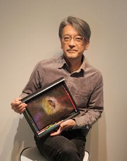 自身の作品「色鉛筆と少年」を手にするクリエーターのこうづなかば氏 写真=筆者提供