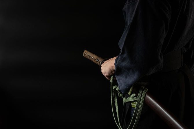 腰に日本刀を差した男性