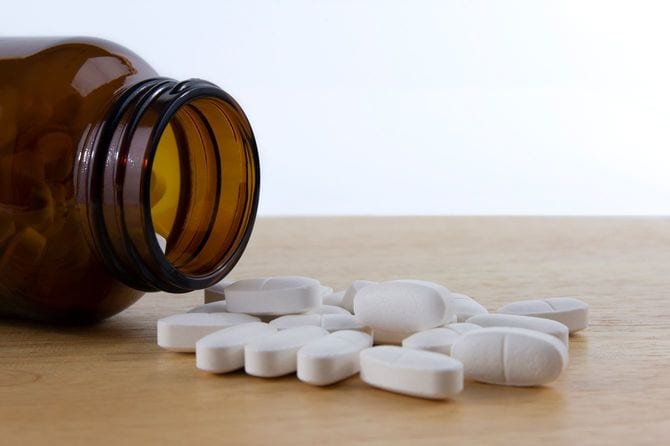 容器からテーブルにこぼれた白い薬