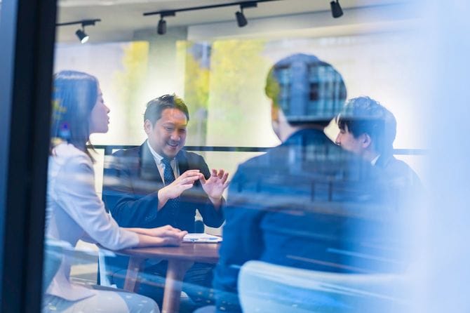 オフィスで話すビジネスパーソン