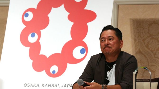 2025年大阪・関西万博のロゴマークに決まった「TEAM INARI（チームイナリ）」の作品と代表のシマダタモツさん＝2020年8月25日、大阪市北区