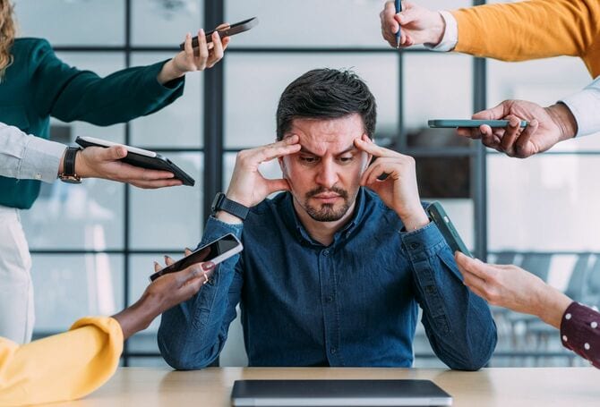 大量のタスクを提示されて頭を抱えるビジネスマン