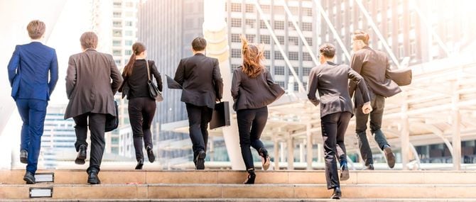 都市の屋外の階段を駆け上がっている人々