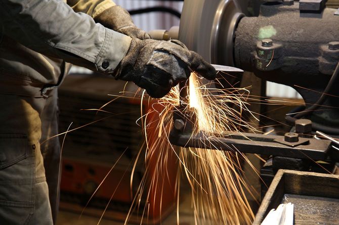 工場で金属の研磨作業をする作業員