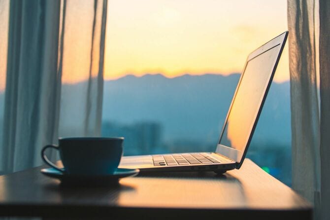 日没時の窓とテーブルの上のラップトップ
