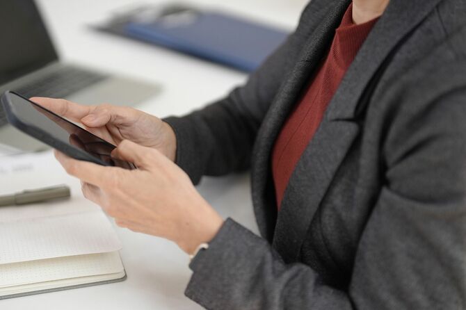 会社デスクでスマホを触る女性