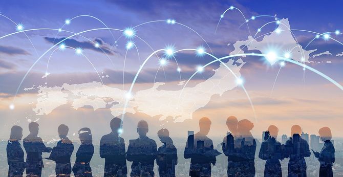 グローバルネットワークのイメージと、ビジネスパーソンのシルエット