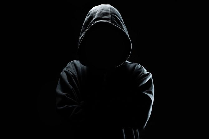 黒のパーカーのフードを被った人の顔は見えない