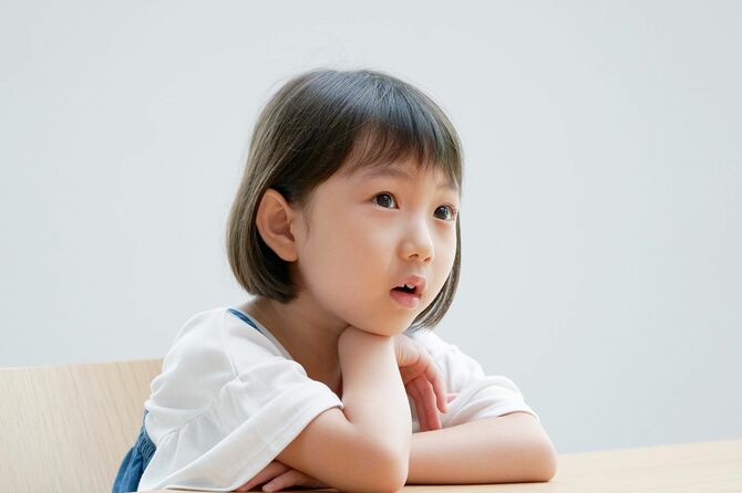 椅子の上で考えている女の子