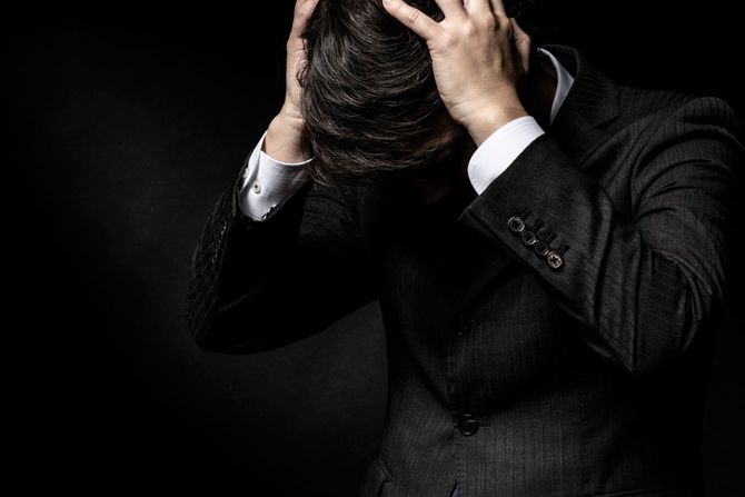 頭を抱えて困った男