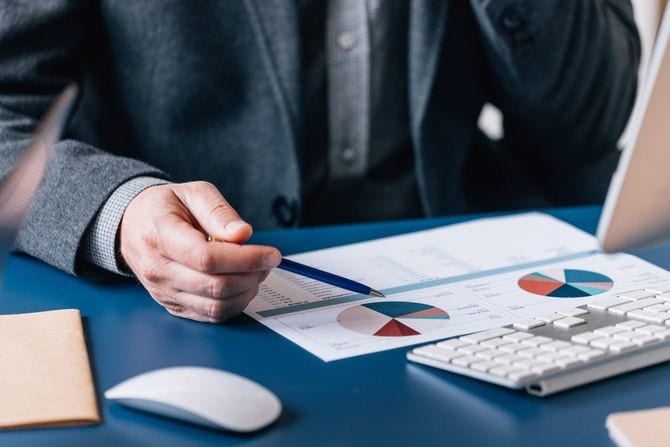 机の上の財務グラフを分析するビジネスマン