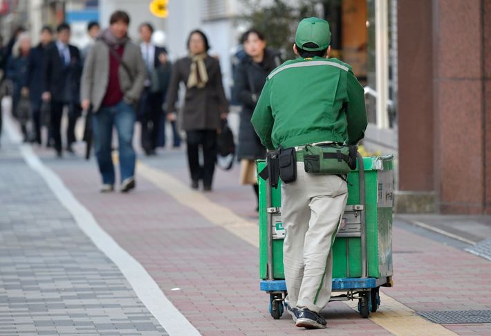 2017年2月28日、荷物を入れた台車を運ぶヤマト運輸の配達員。宅配便国内最大手のヤマト運輸は、インターネット通販の普及とともに急増している荷受量を抑制する検討を始めた。労働組合の要求を受け、ドライバー不足や長時間労働の常態化など労働環境の悪化に対応する