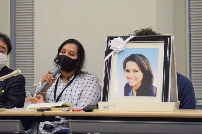 死亡したスリランカ人女性・ウィシュマ・サンダマリさんの遺影を横に記者会見する妹のポールニマさん＝2021年10月5日、東京都千代田区