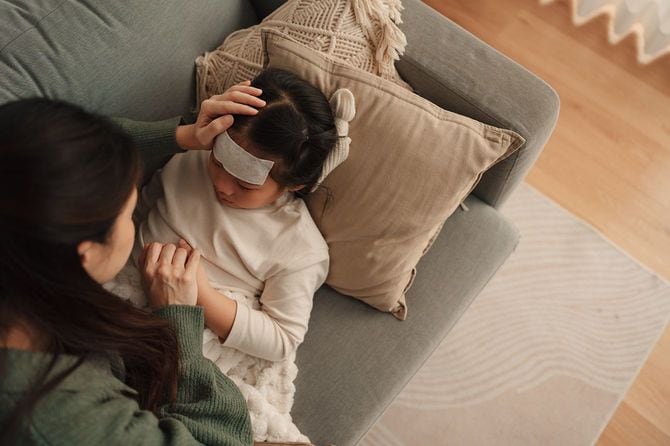 風邪の子供の面倒をみる母親